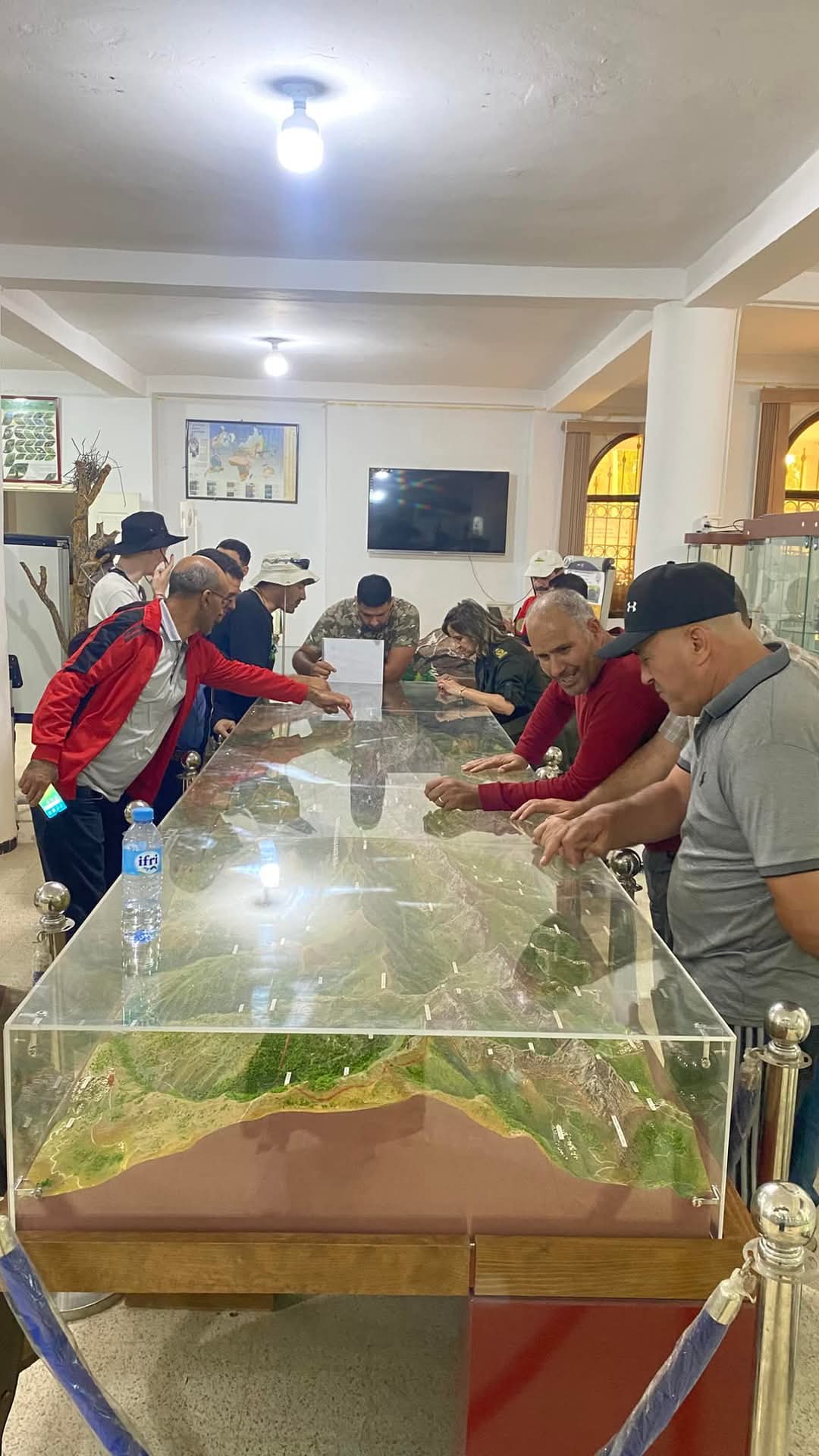 Photo des membres de l'association autour d'un maquette représentant une chaîne de montagne